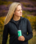 Woman holding a can in a field with blurred background