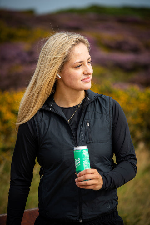 Woman holding a can in a field with blurred background
