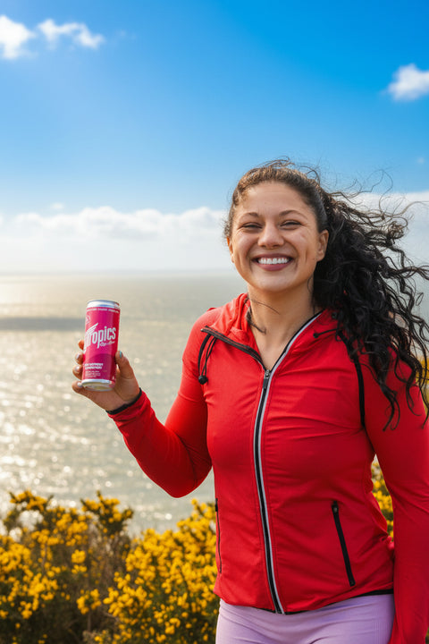 Woman in red jacket holding a pink can outdoors with a cloudy sky.